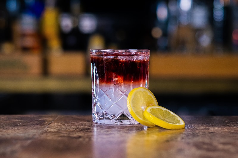 primitivo-cocktail-auf-bartresen-mit-zitronen